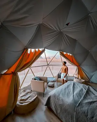 a man is sitting in a tent at BUBBLES CAMp in Wadi Rum