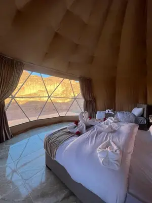 a large bed in a room with a large window at Desert Stars Bubble Camp Wadi Rum in Wadi Rum