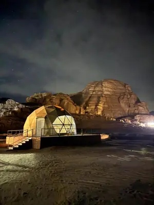 a tent on the water in front of a mountain at Desert Stars Bubble Camp Wadi Rum in Wadi Rum