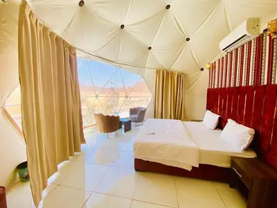 a bedroom with a bed and a large window at Desert Stars Bubble Camp Wadi Rum in Wadi Rum