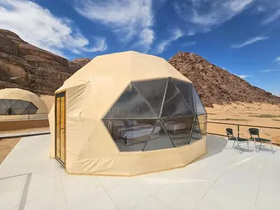 a tent on a roof with chairs in the desert at Desert Stars Bubble Camp Wadi Rum in Wadi Rum