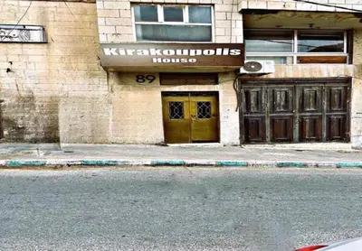 a building with a yellow door on a street at Kirakoupdolis house & restaurant in Kerak