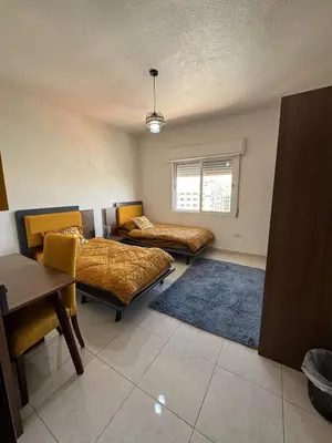a room with two beds and a table and chairs at 2bedroom-2bathroom-furniture in Amman