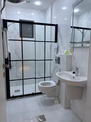 a white bathroom with a toilet and a sink at ريڨا للأجنحة السكنية Riva suites in Irbid