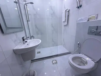 a white bathroom with a toilet and a sink at ريڨا للأجنحة السكنية Riva suites in Irbid