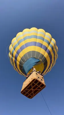 a yellow and blue hot air balloon in the sky at Aseel camp rum in Wadi Rum