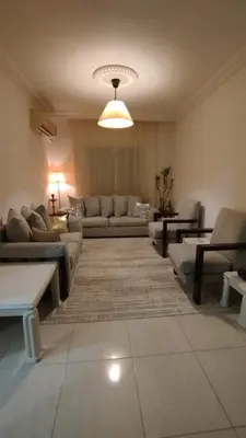 a living room with couches and tables and a light at حي الجامعة خلف الجامعة الاردنية in Amman
