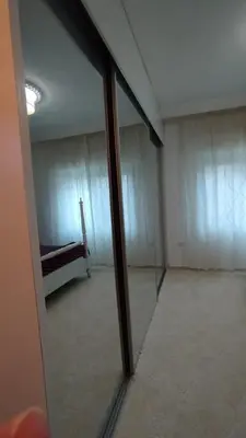 a mirror reflecting a room with a bed in it at حي الجامعة خلف الجامعة الاردنية in Amman