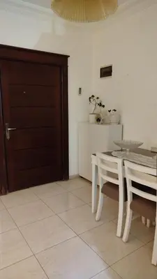 a dining room with a table and chairs and a door at حي الجامعة خلف الجامعة الاردنية in Amman