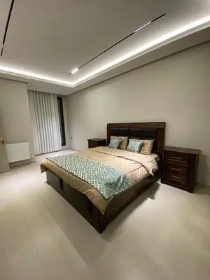 a bedroom with a large bed and a night stand at Luxury apartment for rent in BoulevardAirport Road in Amman