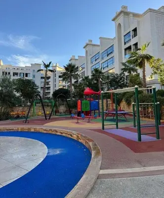 a playground in a city with swings and a playground at Luxury apartment for rent in BoulevardAirport Road in Amman