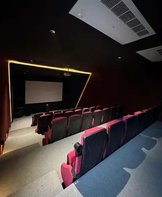 an empty auditorium with red chairs and a projection screen at Luxury apartment for rent in BoulevardAirport Road in Amman