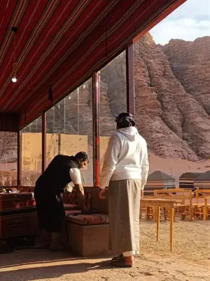 two people standing in front of a building in the desert at Bubble's Home in Wadi Rum