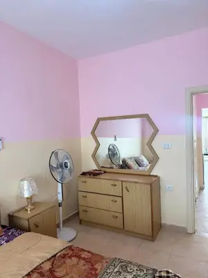 a bedroom with a mirror and a dresser with a fan at panorama sea view apartment in Sowayma