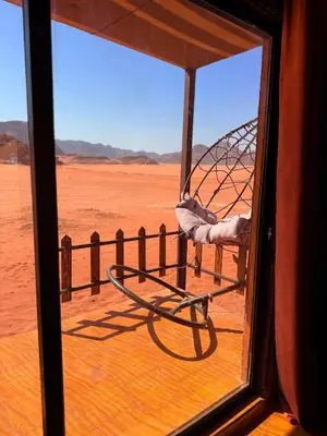 a view from a window of a hammock in the desert at Desert Moon Camp in Wadi Rum