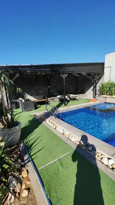 a backyard with a swimming pool and green grass at LP chalet deadSea view in Sowayma