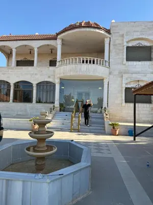 a man standing in front of a building at Villa Qsai alnerat in Riḩāb