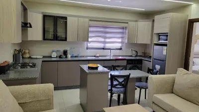 a large kitchen with a table and chairs in a room at Lavender Résidence in Amman