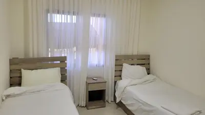 two beds in a room with a window at Lavender Résidence in Amman