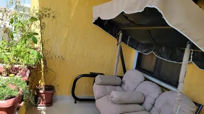 a couch and an umbrella next to a building at Lavender Résidence in Amman
