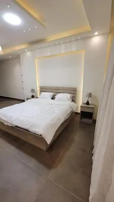 a bedroom with a large white bed in a room at Lavender Résidence 102 in Amman