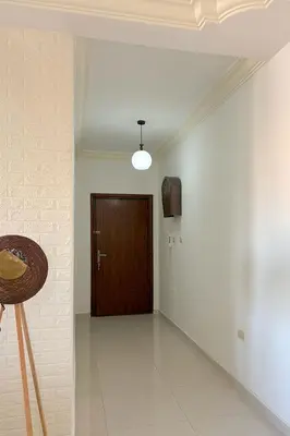a hallway with a door and a table and a chair at Comfy Apt at Jandawil -only Families- in Amman