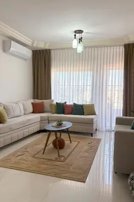 a living room with a couch and a table at Comfy Apt at Jandawil -only Families- in Amman