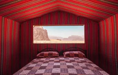 a red room with a bed with a window at Wadi Rum Moon Light in Wadi Rum