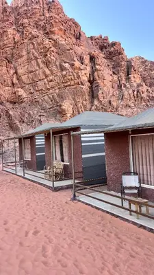 a building in the desert next to a mountain at Wadi Rum Moon Light in Wadi Rum