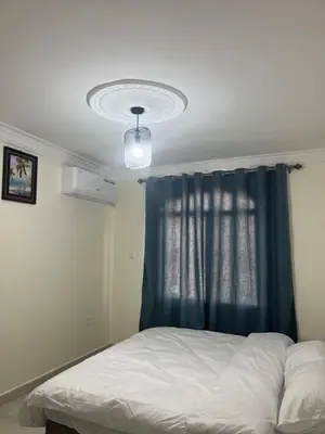 a bedroom with a bed and a blue curtain at الحمد للاجنحة الفندقية in Aqaba
