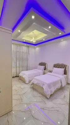 two beds in a room with a purple ceiling at شقق فندقيه فخمه للايجار اليومي in Ash Shumaysānī