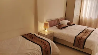 a bedroom with two beds and a lamp on a night stand at hotel amman in Amman