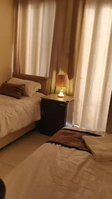 a bedroom with two beds and a lamp on a night stand at hotel amman in Amman