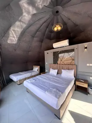 a bedroom with a large bed and a ceiling at Rum Ronza Luxury Camp in Maḩaţţat Dīsah