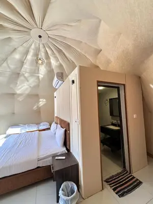 a bedroom with a bed and a ceiling with a mirror at Rum Ronza Luxury Camp in Maḩaţţat Dīsah