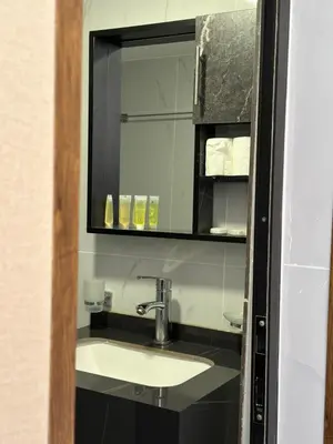 a bathroom with a sink and a mirror at Rum Ronza Luxury Camp in Maḩaţţat Dīsah