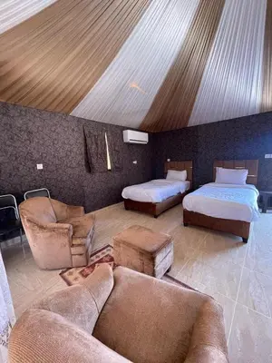 a living room with two beds and a couch at Rum Ronza Luxury Camp in Maḩaţţat Dīsah