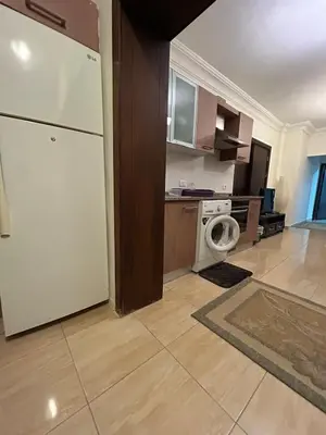 a kitchen with a white refrigerator and a washing machine at Cozy 1BR in Abdoun Quiet Near US Embassy in Amman