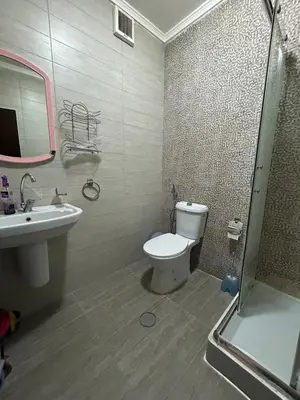 a bathroom with a toilet and a sink and a shower at Cozy 1BR in Abdoun Quiet Near US Embassy in Amman
