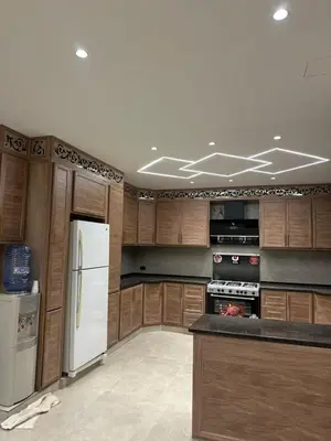 a kitchen with wooden cabinets and a white refrigerator at شاليه الدرة Durra Chalet in Amman
