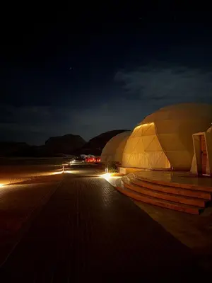 a large domed building with lights at night at Rum Rose Night in Wadi Rum