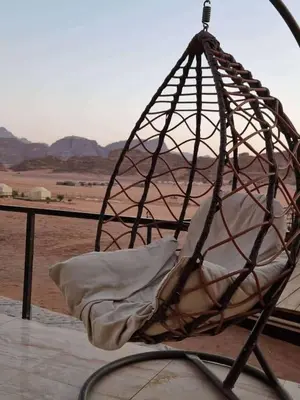 a hanging bed with a pillow in a cage at Rum Rose Night in Wadi Rum