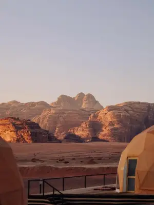 a tent in the desert with mountains in the background at Rum Rose Night in Wadi Rum