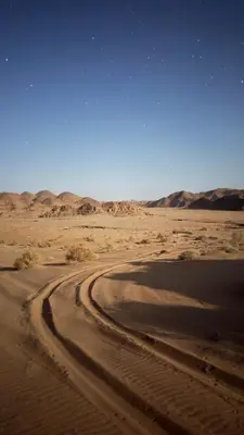 a dirt road in the desert with mountains in the background at HALA RUM Luxury camp & Bubbles Hotel in Disah