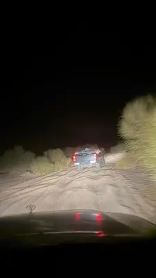 a car driving down a road at night at HALA RUM Luxury camp & Bubbles Hotel in Disah