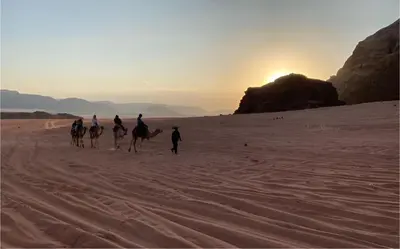 a group of people riding horses in the desert at Mohammad rum camp in Disah