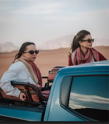 two women sitting in the back of a car at Mohammad rum camp in Disah