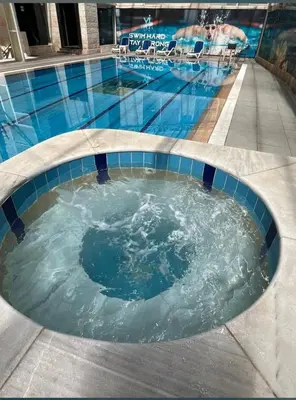 a swimming pool with a jacuzziificialificialificialificialificialificialificial at Badan Suites & Hotel in Amman