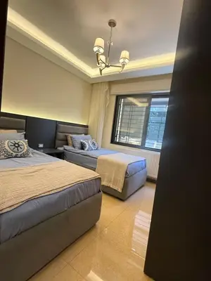 a hotel room with two beds and a window at مطر in Amman