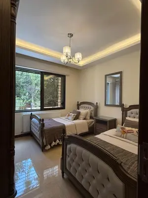 a bedroom with two beds and a large window at مطر in Amman